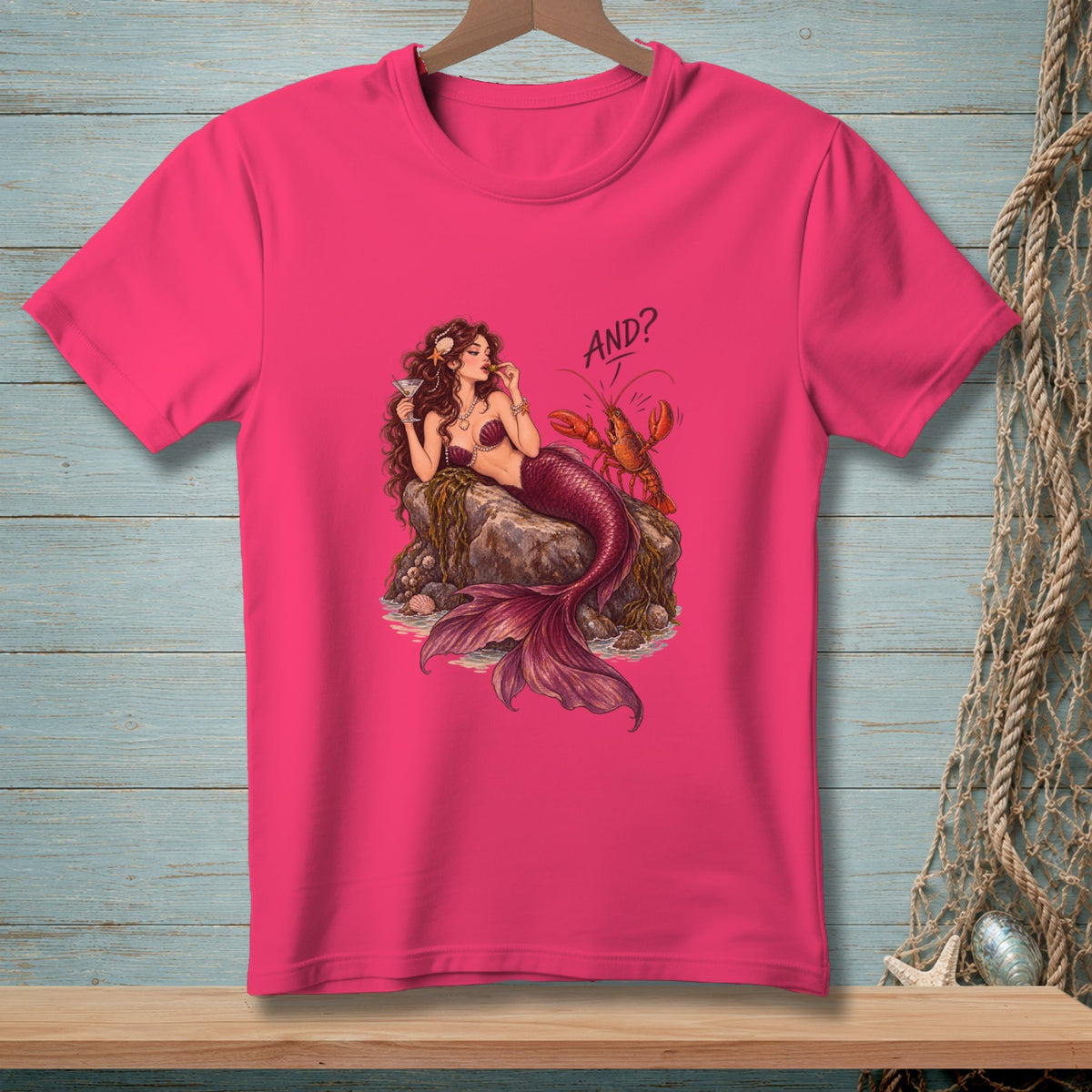 Pink t-shirt with illustration of a mermaid and lobster and text "AND?".