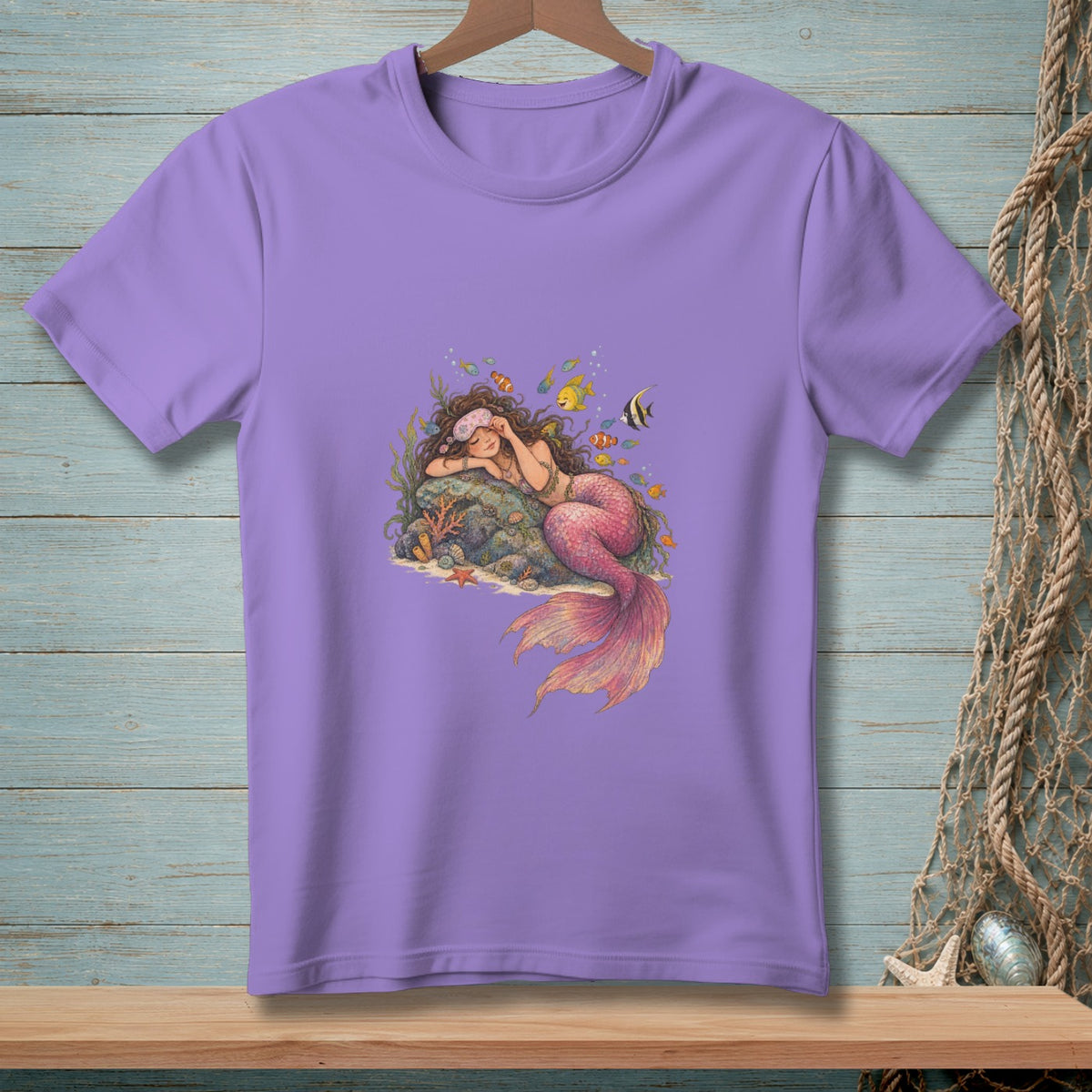 Purple t-shirt with a sleeping mermaid and fish illustration on the front.