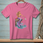 Pink t-shirt with mermaid sitting on a dock, holding champagne and tossing a seashell that says "DONE".