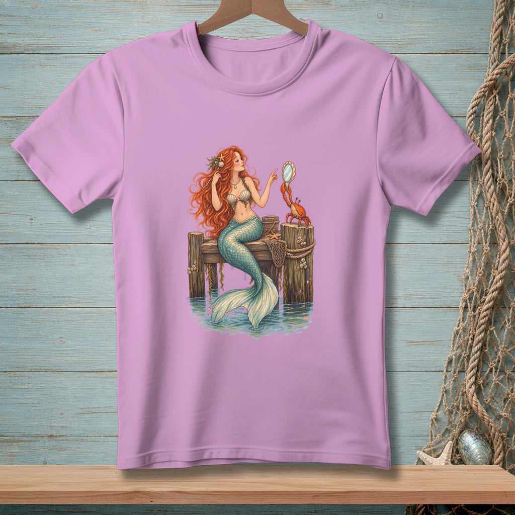 Mermaid holding mirror with crab on wooden pier, printed on a pink t-shirt.