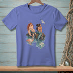 Two mermaids sit on rocks in the water with a seagull flying overhead.