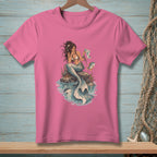 Pink t-shirt featuring a mermaid sitting on a rock with a map and a fish.
