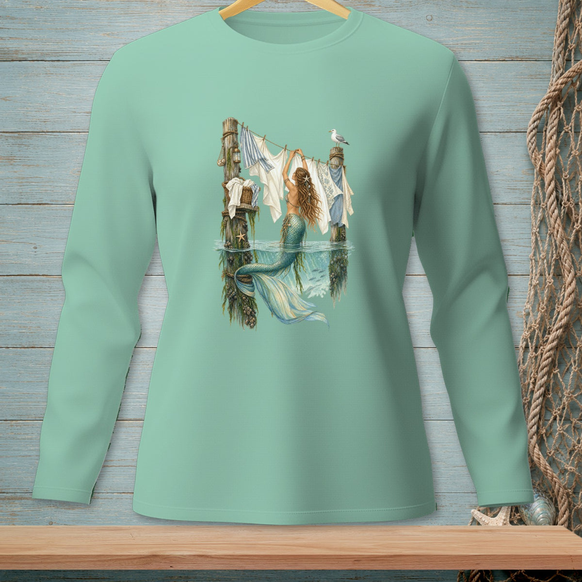 Mermaid hanging laundry on a clothesline in the ocean with a seagull.