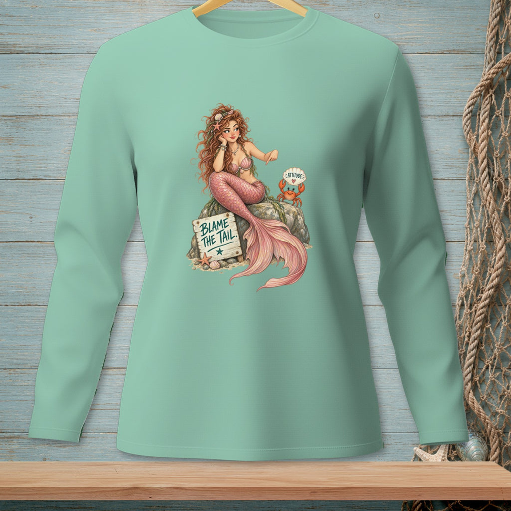 Mermaid sitting on rock with a crab, text reads "Blame the Tail."