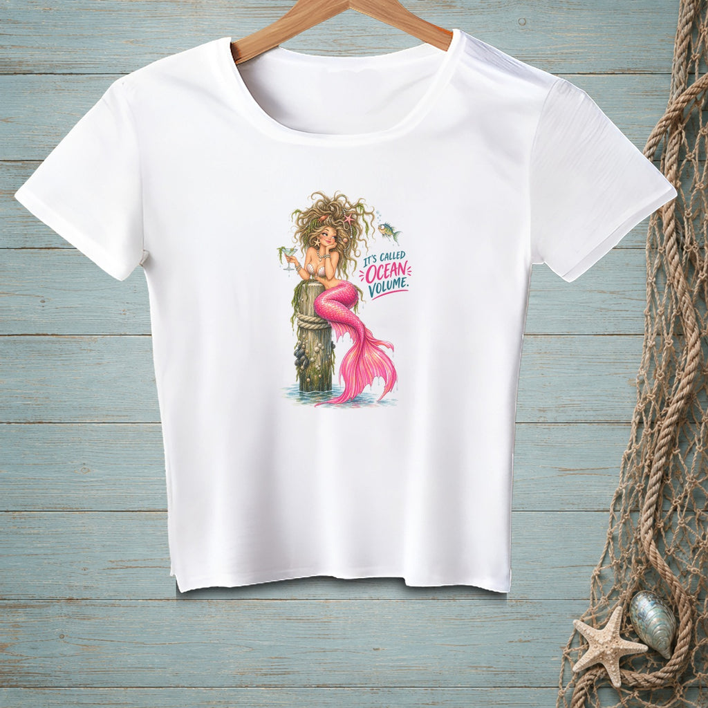 White t-shirt with a mermaid design saying "It's Called Ocean Volume."