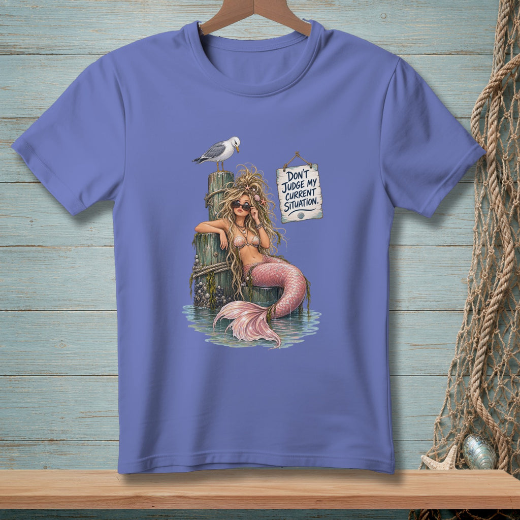 Purple t-shirt with a mermaid on a pier and text saying "Don't judge my current situation."
