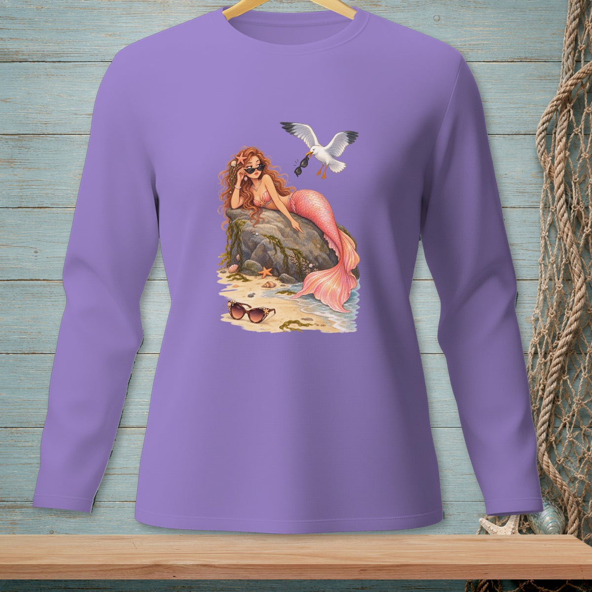 Mermaid with pink tail, sunglasses, and seagull with sunglasses on a beach.