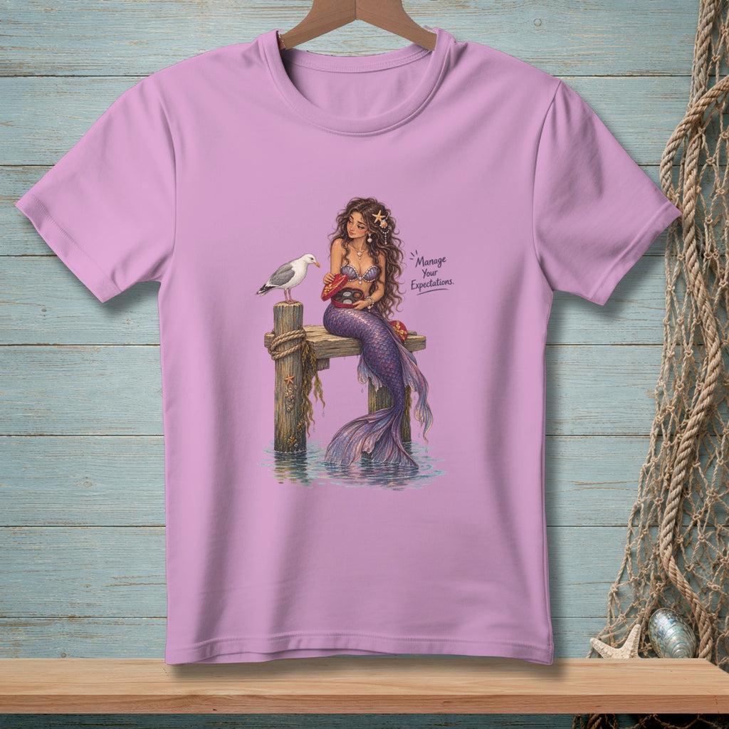 Mermaid on dock with seagull, offering chocolates, text "Manage Your Expectations."