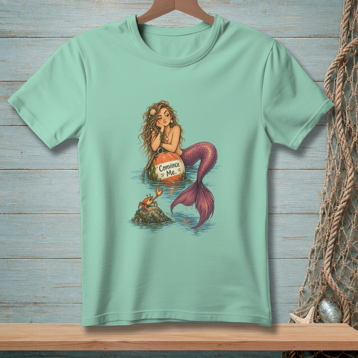 Mermaid with text "Convince Me" on a buoy, with a crab on a rock.
