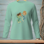 Two mermaids with colorful tails share drinks and snacks on a teal long-sleeve shirt.