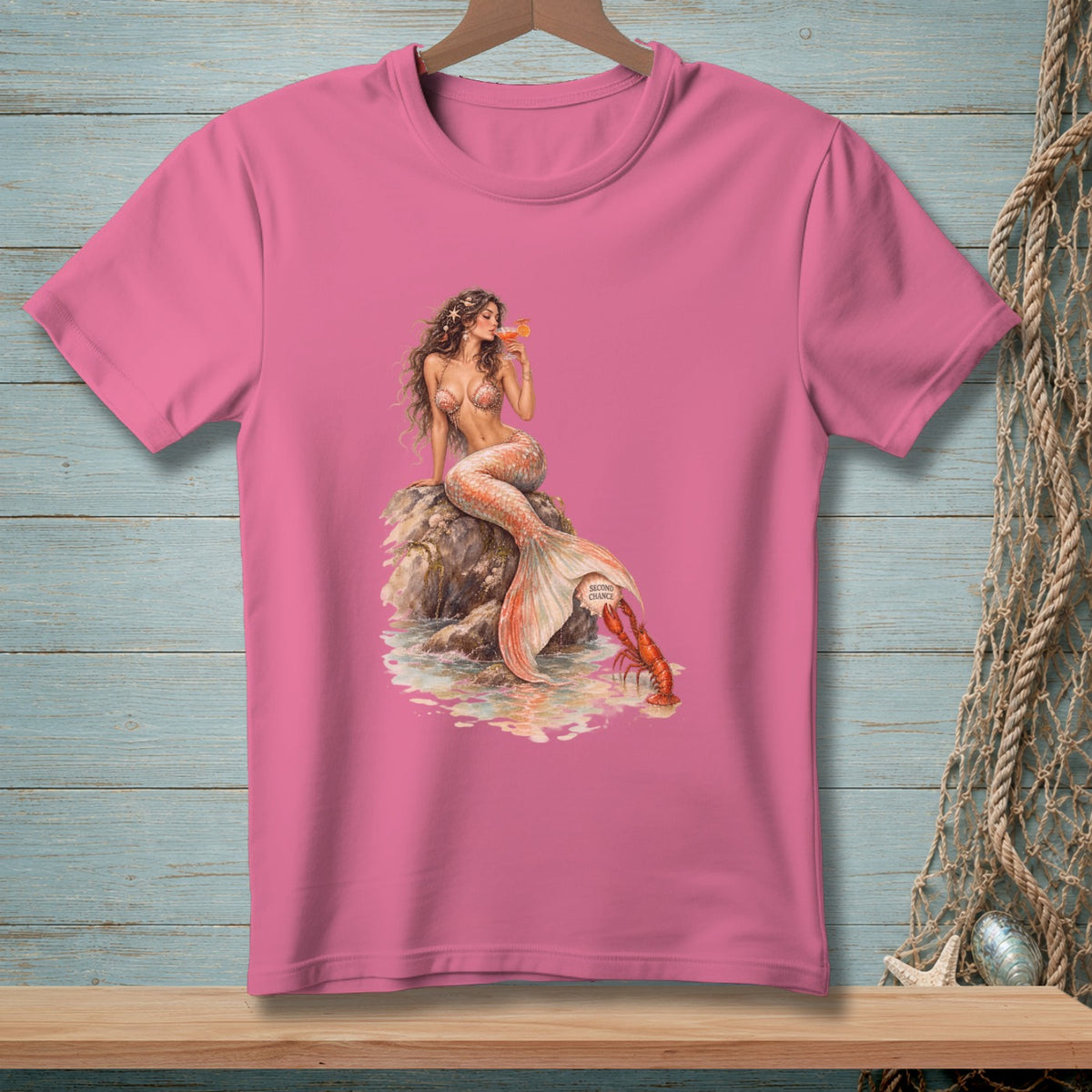Pink t-shirt with a mermaid holding a drink and a lobster at her tail.