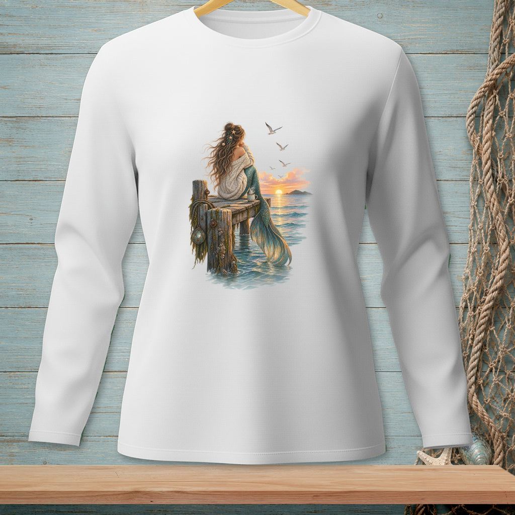 Illustration of a mermaid sitting on a dock at sunset with seagulls overhead.