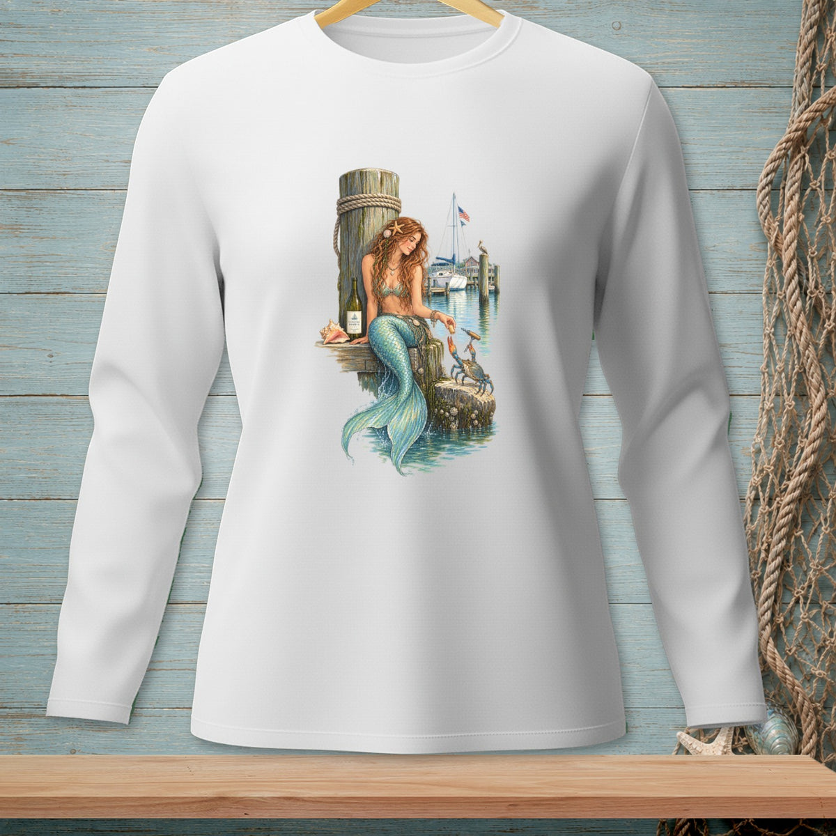 Mermaid on a dock feeding a crab, with a sailboat in the background.