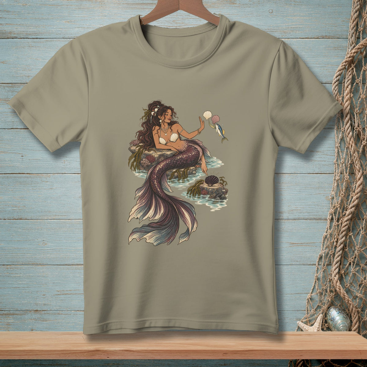 T-shirt featuring a mermaid with a seashell bikini top and iridescent tail holding a pearl.