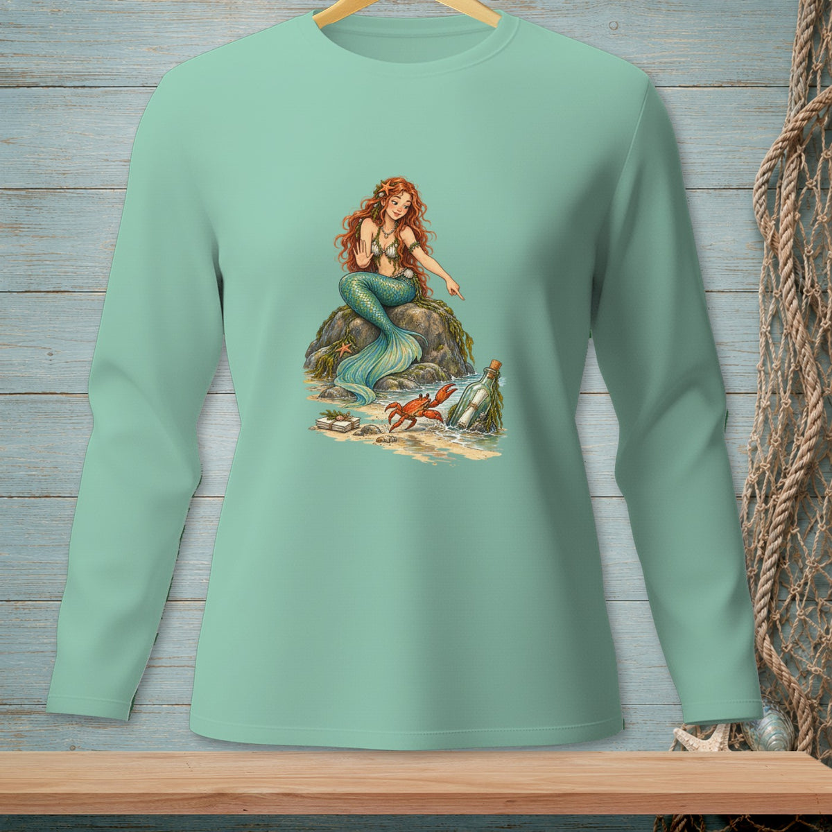 Mermaid on rock with crab and bottle on beach.