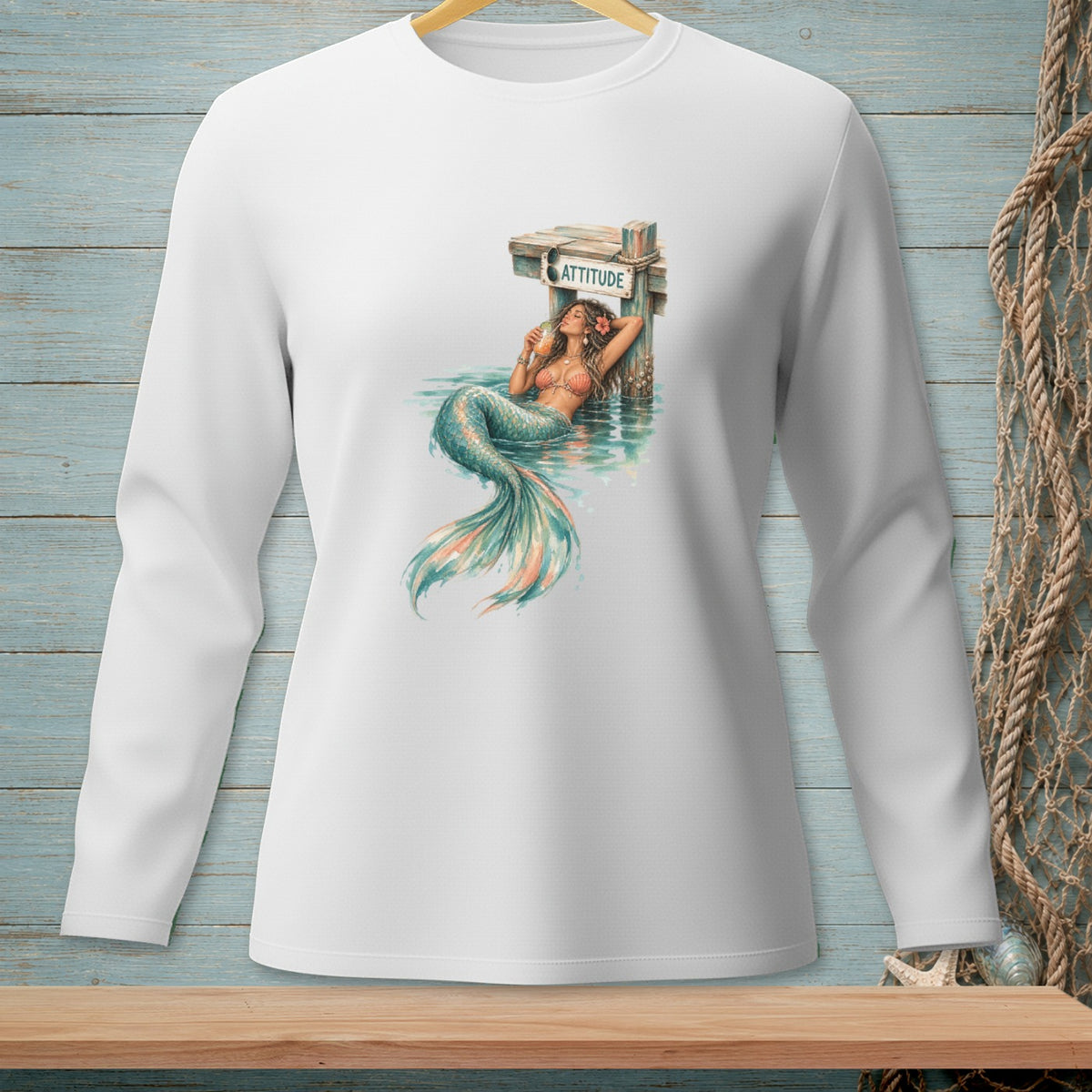Mermaid with drink lounging by a post with the word ATTITUDE and sunglasses.