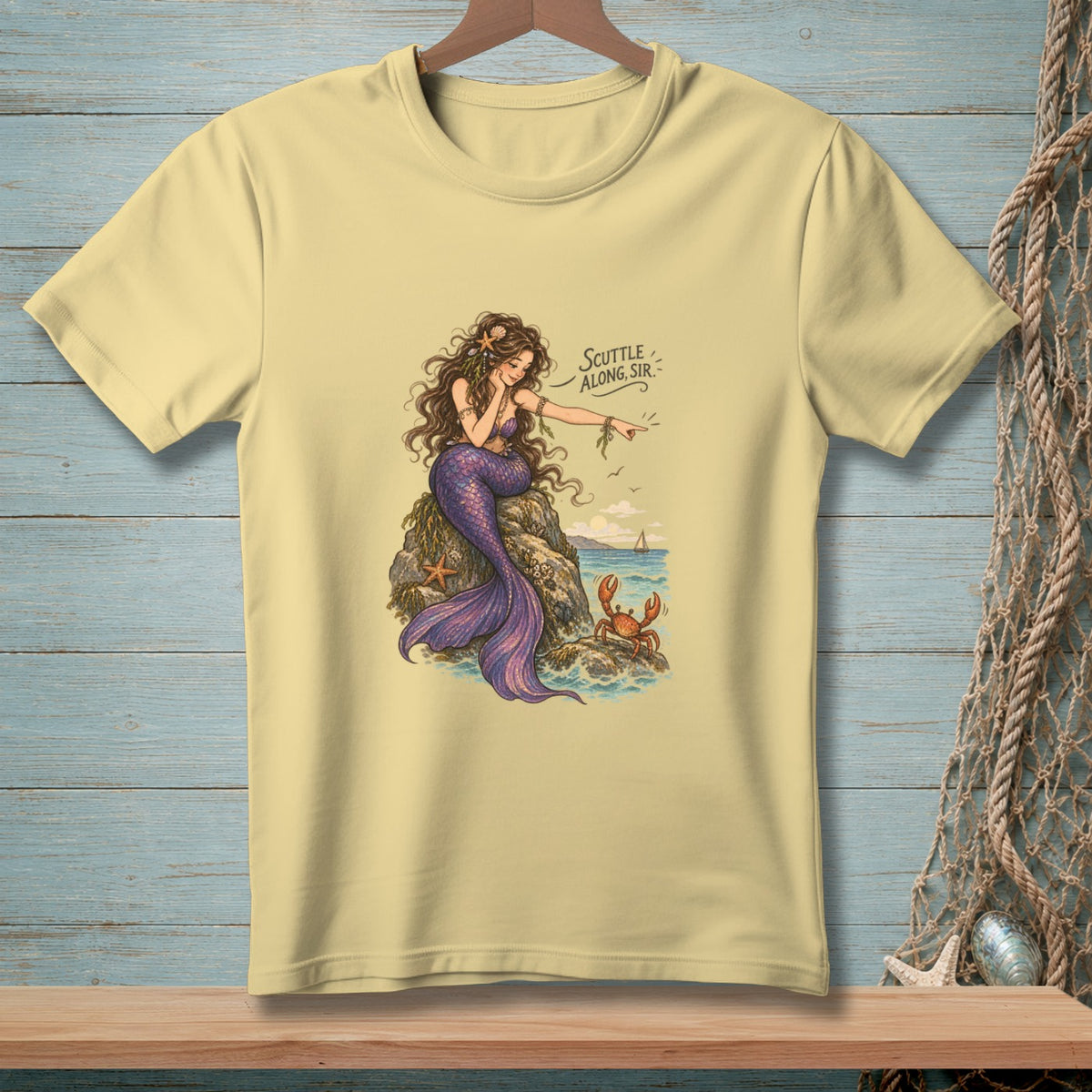 Light yellow t-shirt with a mermaid pointing at a crab, saying "Scuttle along, sir."