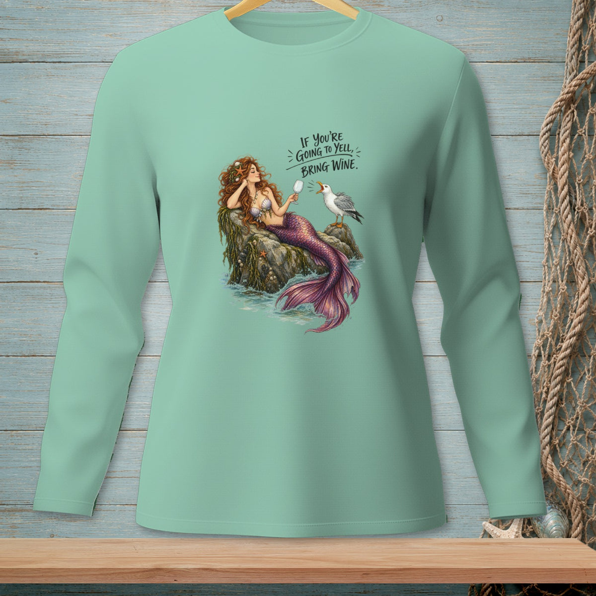 Mint long sleeve shirt with a mermaid and seagull graphic and text.