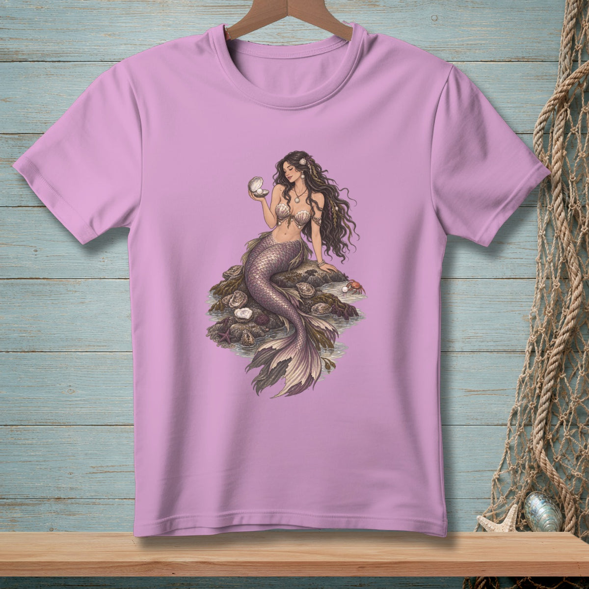 Mermaid sitting on rocks, holding a pearl in an open shell.