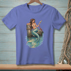 Mermaid with cocktail and crab sitting on dock pilings, teal shirt graphic.