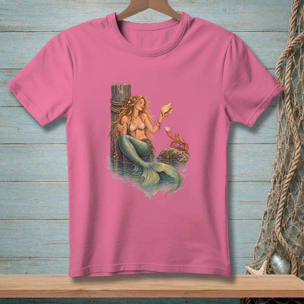 Pink t-shirt featuring a detailed illustration of a mermaid holding a seashell with a crab nearby.