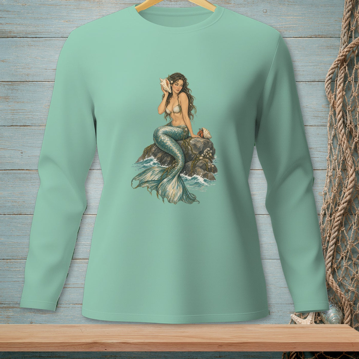 Mermaid holding a seashell sitting on a rock with waves around her.