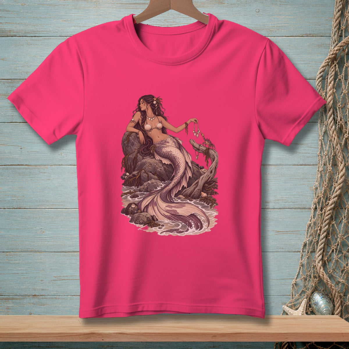 T-shirt with a detailed illustration of a mermaid resting on rocks by the sea.