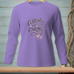 Purple long-sleeve shirt with text "Currently Not Caring" and mermaid tail graphic.