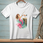 White t-shirt featuring a mermaid fishing from a wooden pier with a human hand.