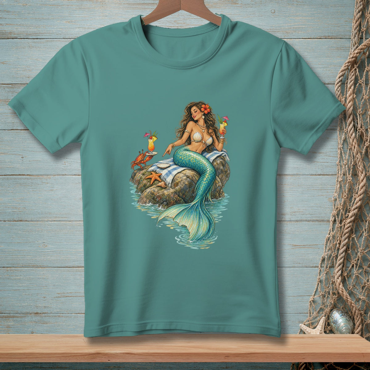Mermaid with crab and cocktail sits on rock with starfish and draped towel.