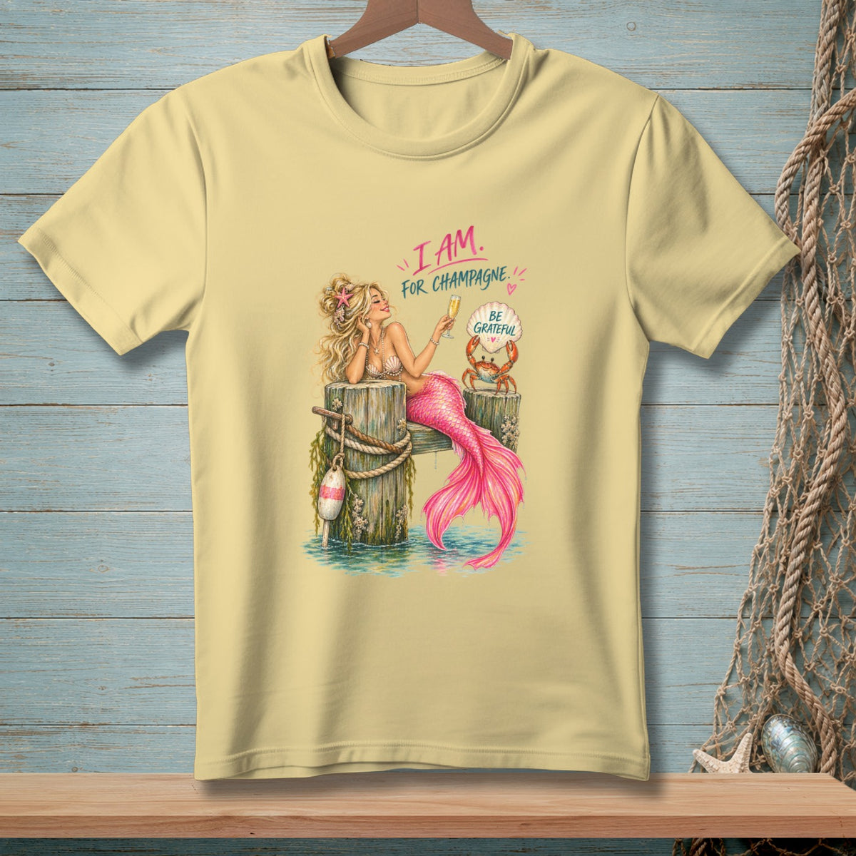 Mermaid with pink tail holding champagne, a crab saying "Be Grateful".