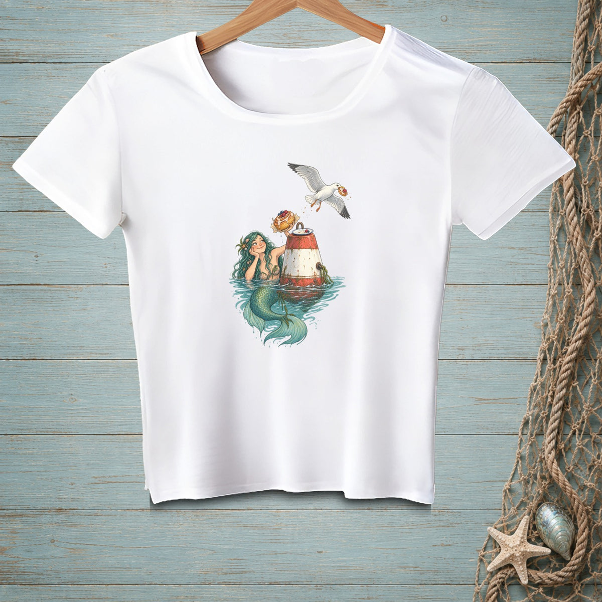 White t-shirt with mermaid, buoy, donut, and seagull graphic.