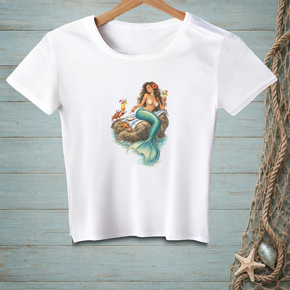 White t-shirt with a graphic of a mermaid holding cocktails on a rock with a crab.
