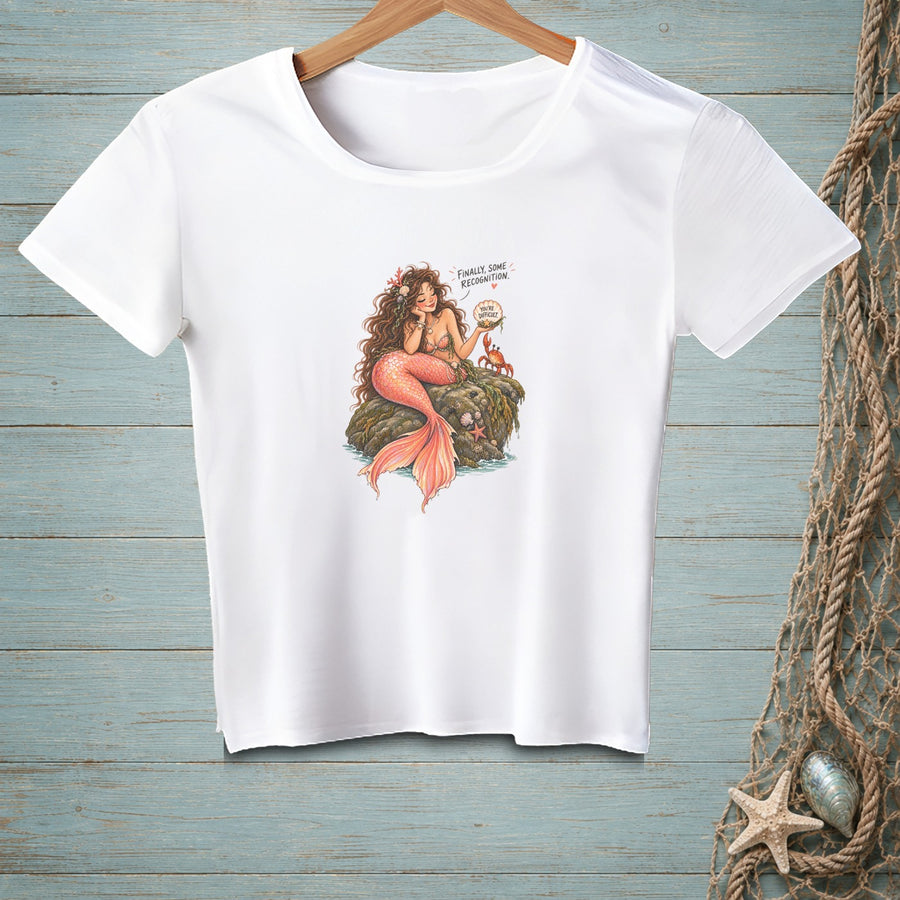 White t-shirt with mermaid illustration, crab, and text bubble.