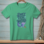 Green t-shirt with text "DON'T TEST the WATERS" and mermaid tail graphic.