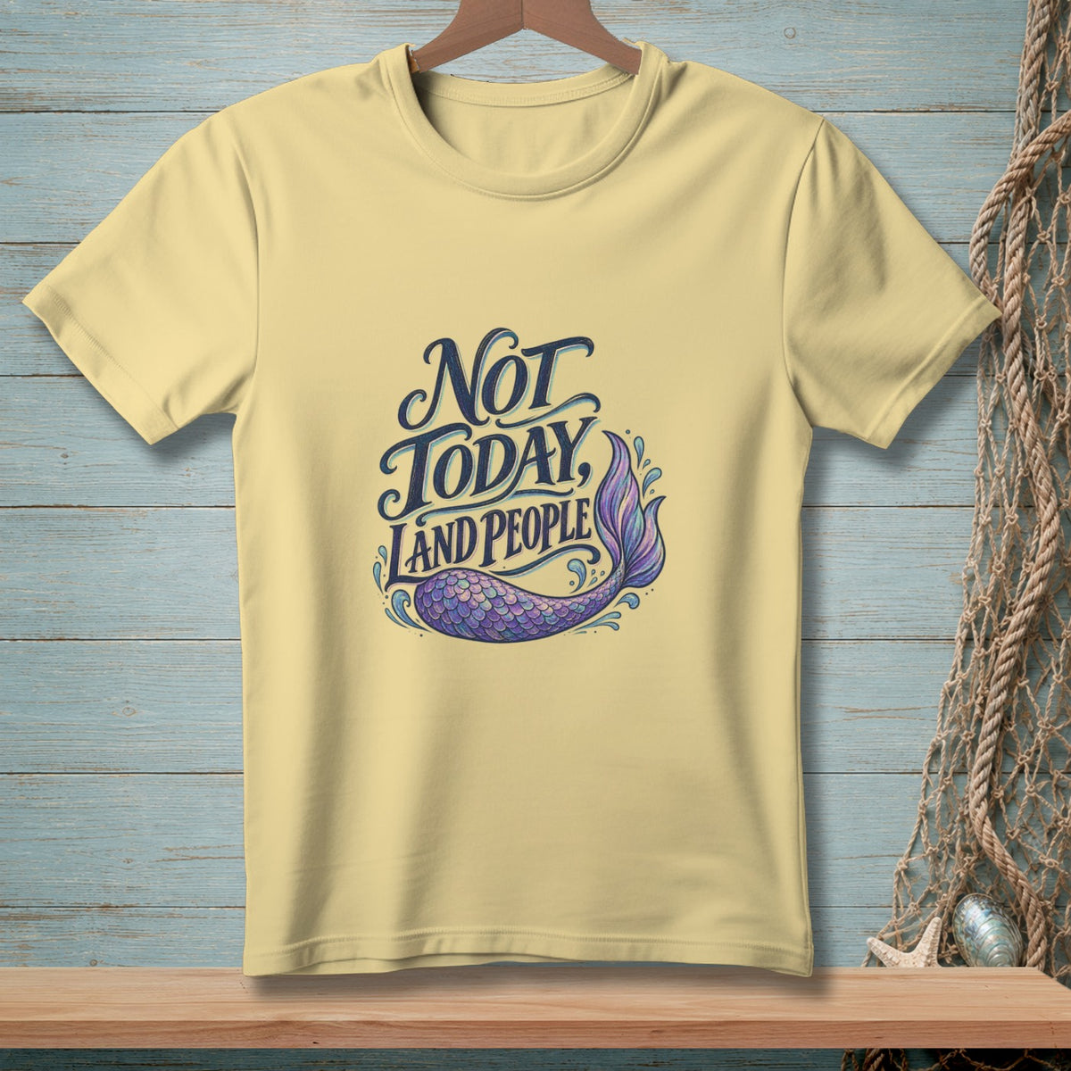 Yellow t-shirt with "Not Today, Land People" text and a purple mermaid tail graphic.