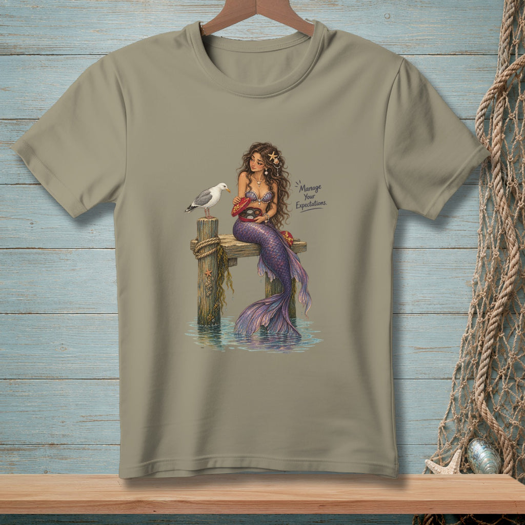 Mermaid on pier with seagull, holding candy box, with text "Manage Your Expectations."