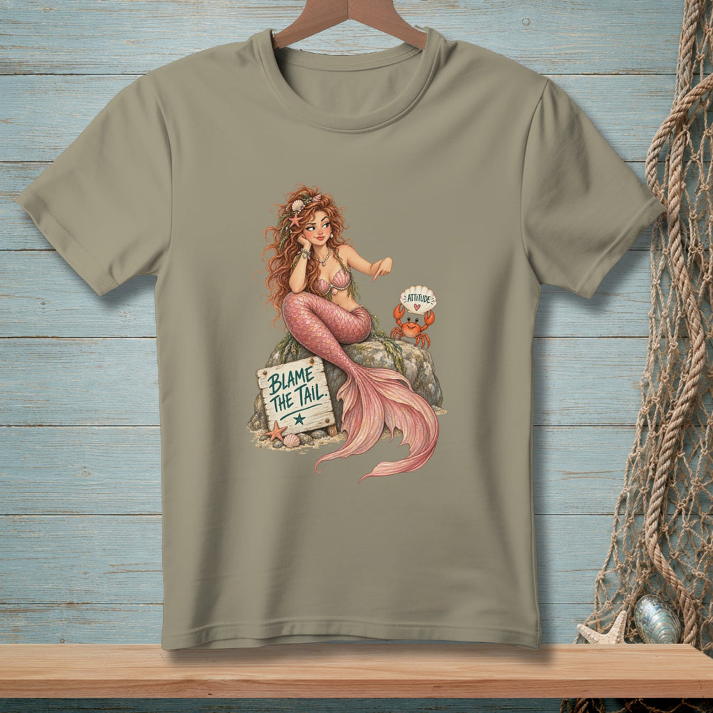 Mermaid sitting on a rock with a crab and a sign that reads "Blame the Tail".