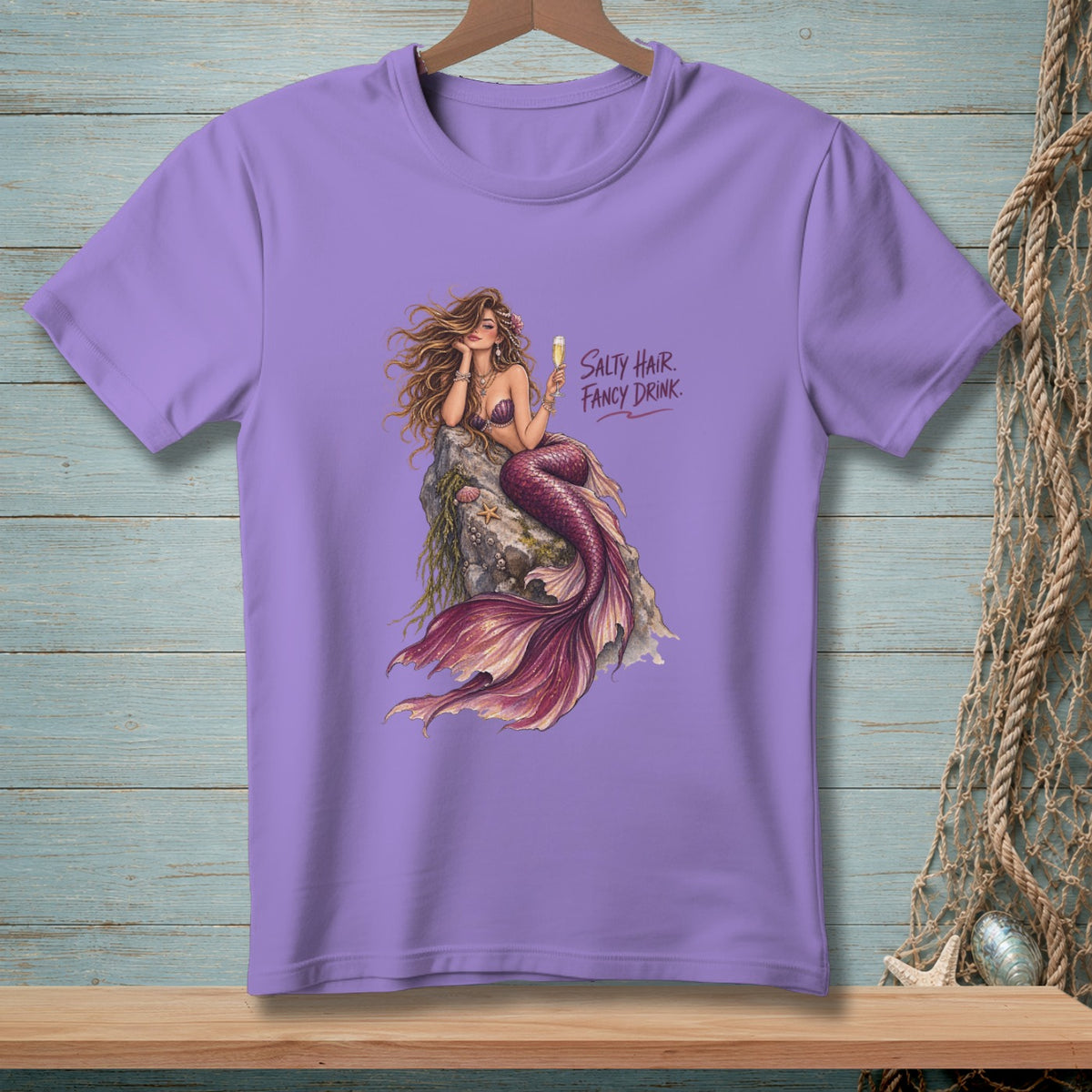 Purple t-shirt with a mermaid illustration and text that reads "Salty Hair. Fancy Drink."