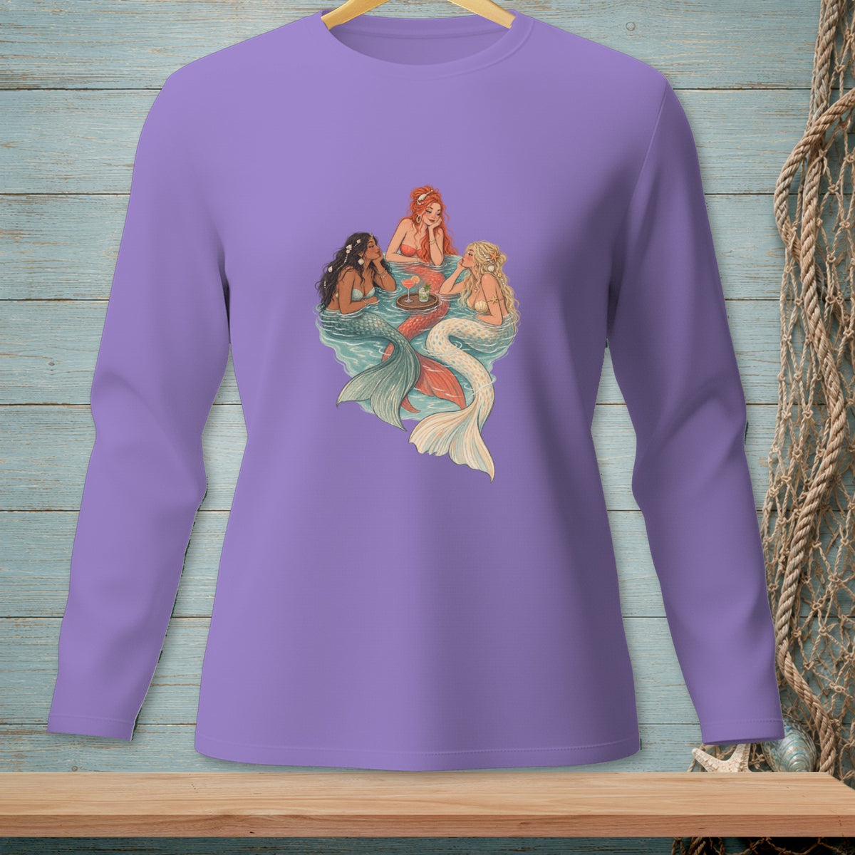 Purple long-sleeve shirt with three mermaids gathered around a tray of drinks.