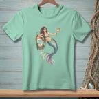 Mint t-shirt with a watercolor mermaid holding a pufferfish near a buoy that reads "GOOD VIBES ONLY."