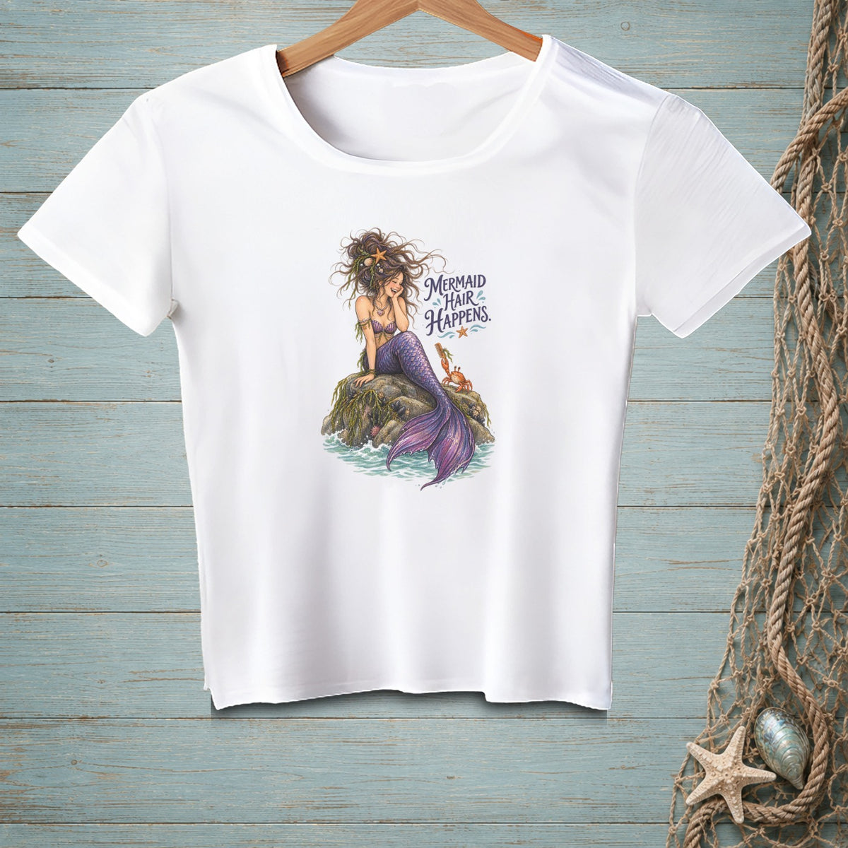 White t-shirt with a mermaid design and "Mermaid Hair Happens" text.