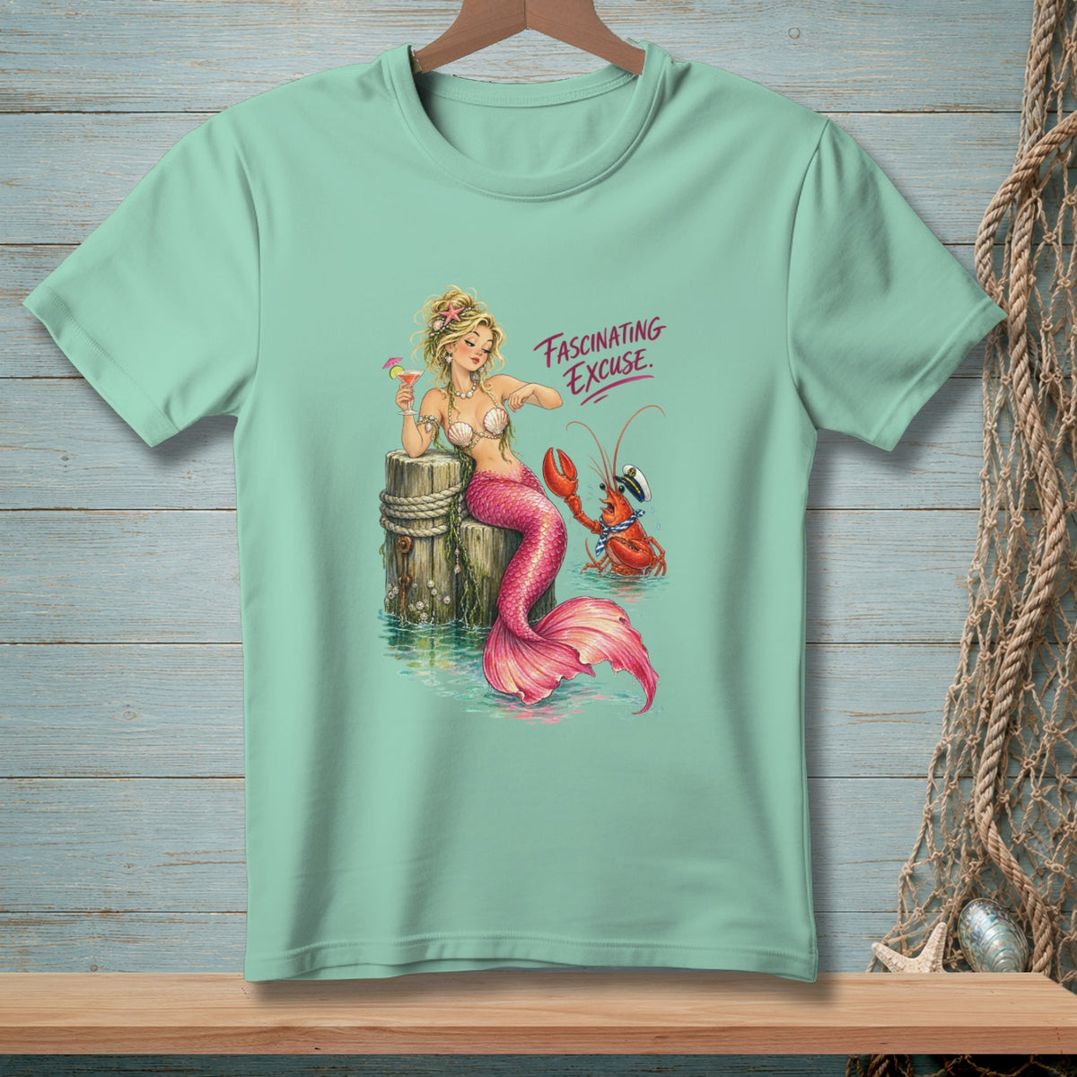 Mint t-shirt with mermaid and lobster graphic, text says "Fascinating Excuse".
