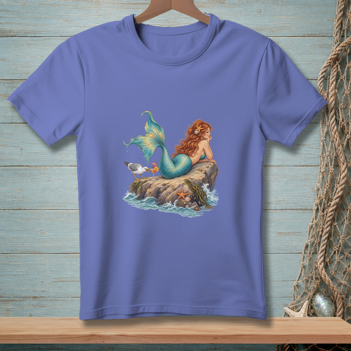 Mermaid with red hair on rock with seagull and starfish, next to ocean waves.