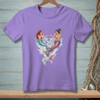 Lavender t-shirt with illustration of two mermaids holding cupcakes in water.