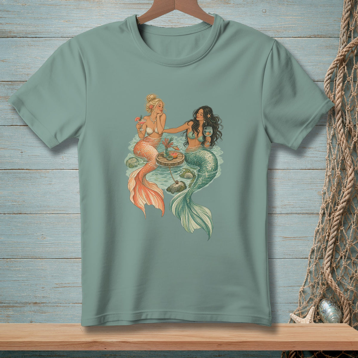 Two mermaids with cocktails on a floating table in water.