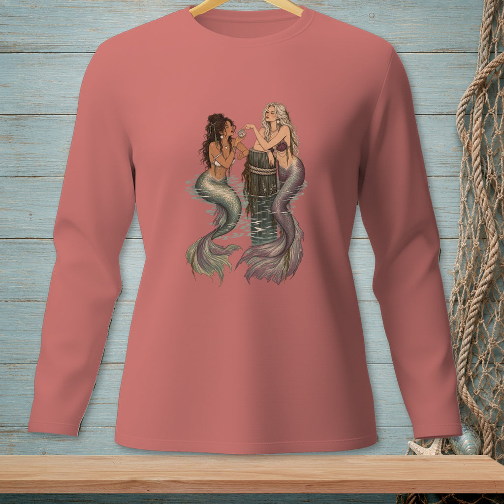 Two mermaids with shimmering tails sit by a barnacle-covered post in the water.