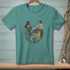 Three illustrated mermaids with different colored tails interacting in water on a teal t-shirt.