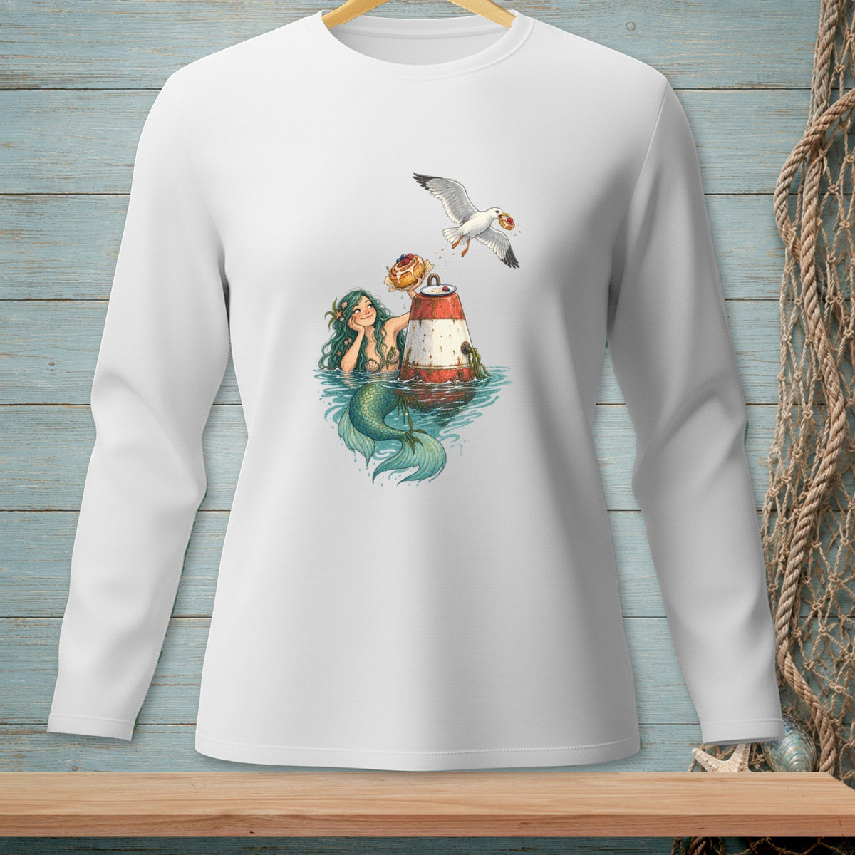 White long-sleeve shirt featuring a mermaid on a buoy with a seagull stealing a donut.