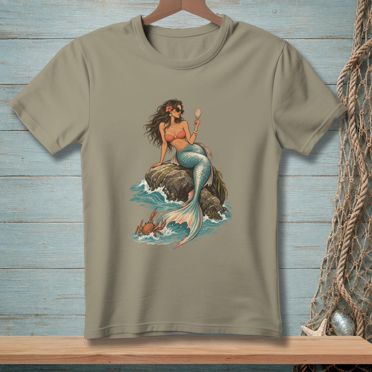 T-shirt with a graphic of a mermaid sitting on a rock holding a shell.